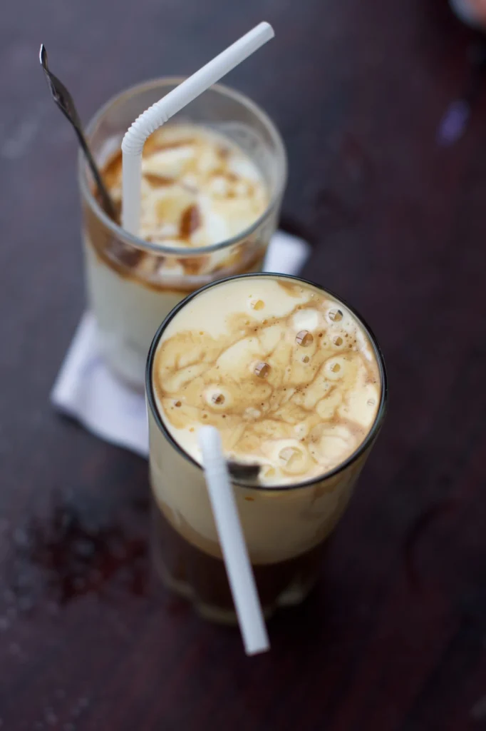 Two glasses of traditional egg coffee with white straws