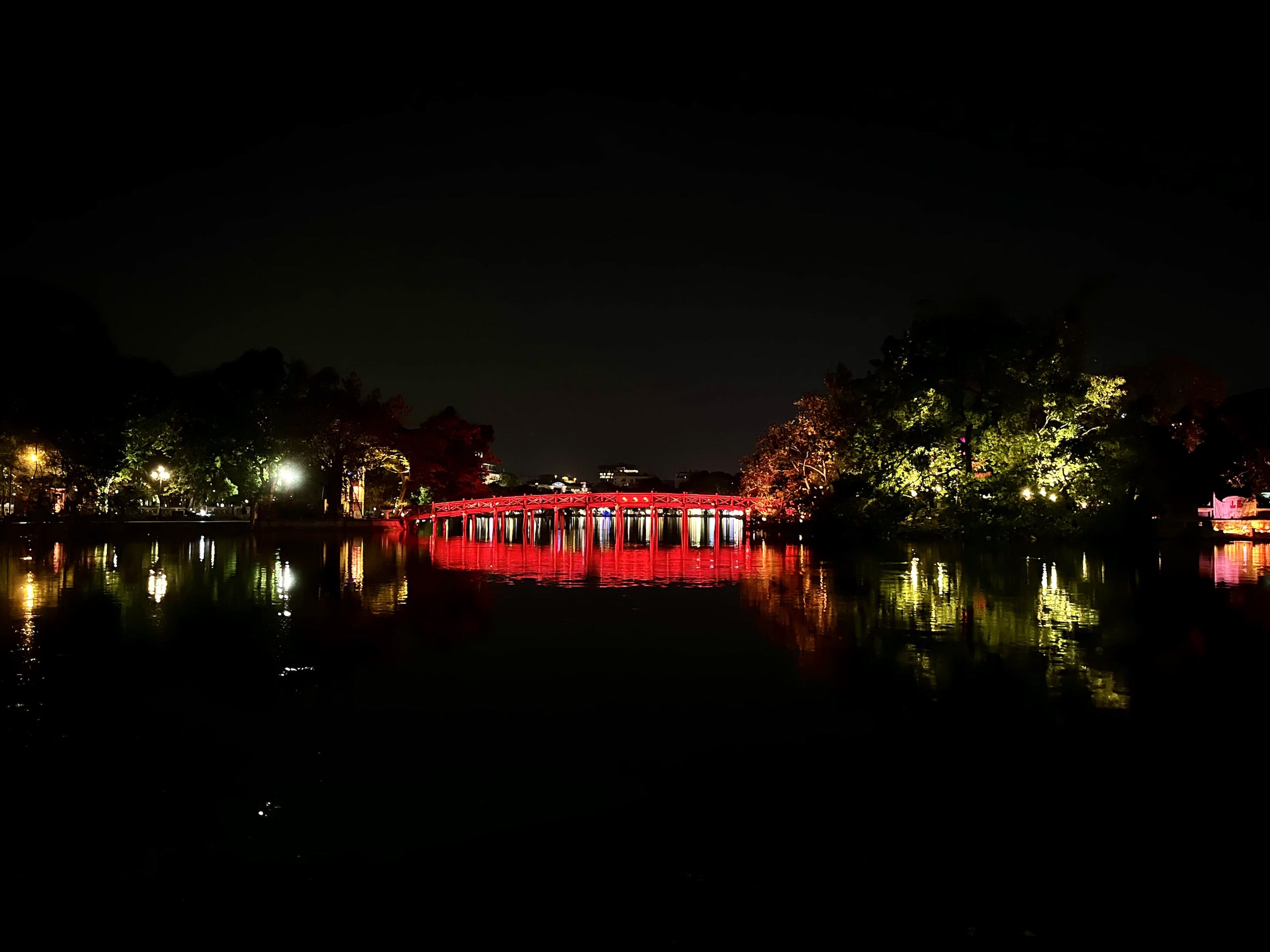 The picturesque red bridge at night on Hoan Kiem Lake in Hanoi's Old Quarter.