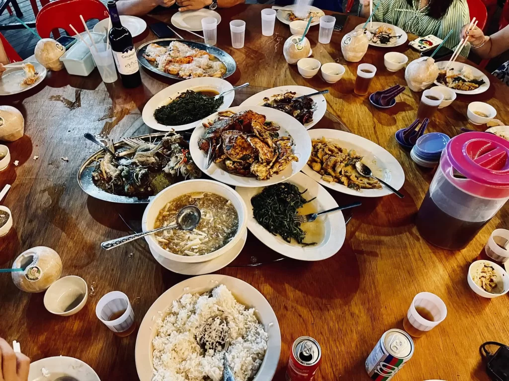 Visiting Semporna: What to Know Before You Dive or Transit 9 A table full of food at the seafood restaurant with friends visiting Semporna