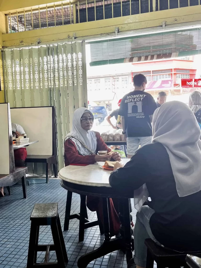 Visiting Semporna: What to Know Before You Dive or Transit 14 Two women having breakfast at Cham Chuan Kee Restaurant in Semporna