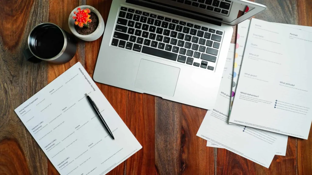 Thai Visa in Kuala Lumpur: How to Apply Successfully 1 A silver laptop und paper forms on top of a desk