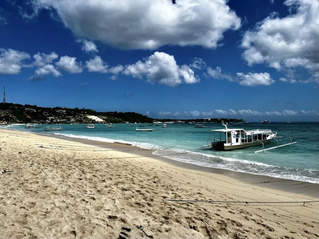 Diving Nusa Penida: The Full Guide to Mantas, Molas & Drifts 11 Small diving boats anchored along the sandy beach of Nusa Penida, ready to take visitors to offshore dive sites.