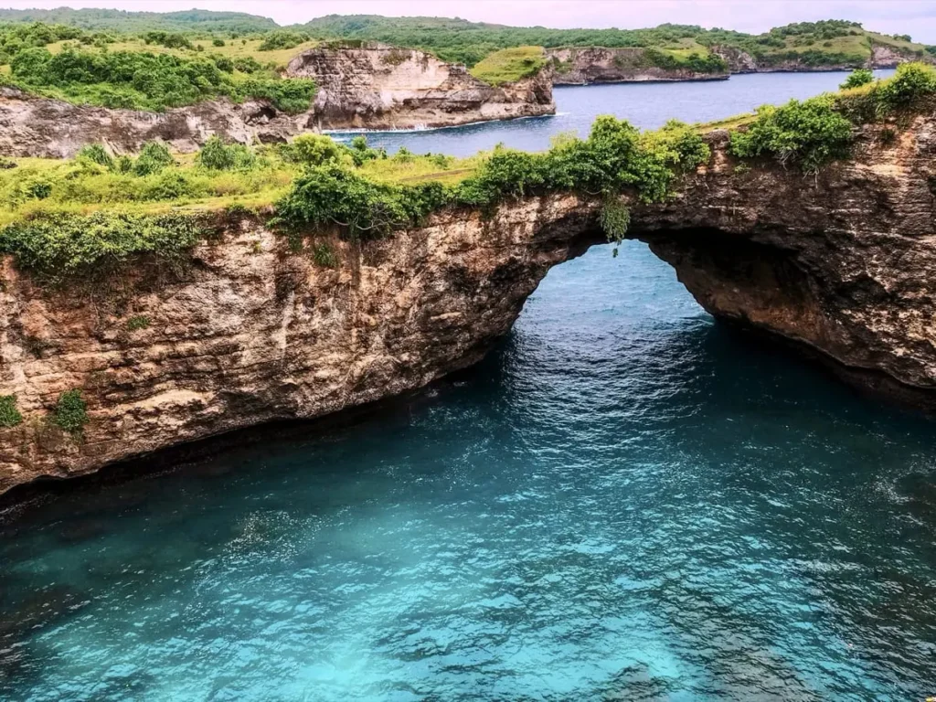 Natural rock arch over turquoise water at Broken Beach, one of the best things to do in Nusa Penida for dramatic coastal scenery.