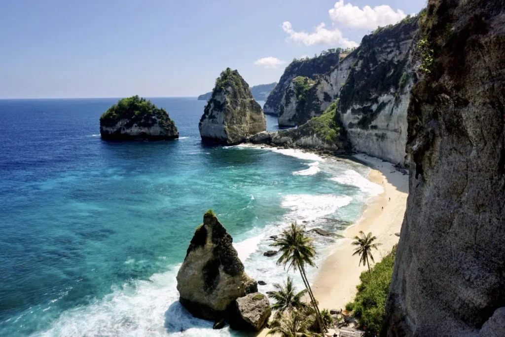 Panoramic view of Diamond Beach with dramatic cliffs, turquoise sea, and white sand, a must-see on any Nusa Penida itinerary.