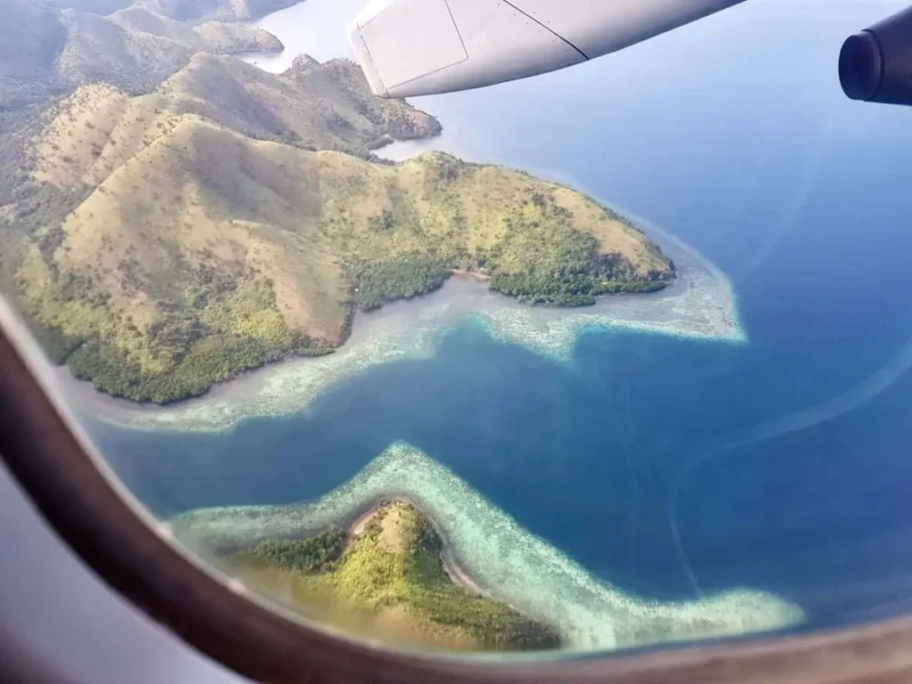 Bangkok nach Koh Tao: So kommst du 2026 auf die Insel 3 Blick aus einem Flugzeugfenster auf der Route von Bangkok nach Koh Tao – grüne, tropische Inseln inmitten von türkisblauem Wasser.